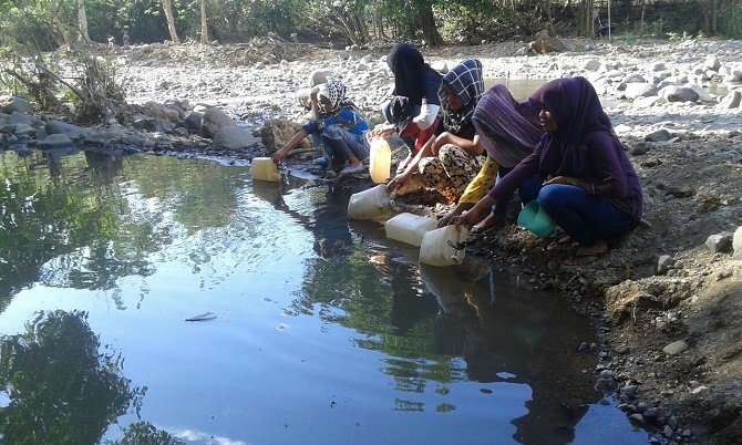 Sejulah warga kampung Kenari Desa Warloka, Manggarai Barat menimba air di kali yang keruh dan menjadi kubangan kerbau (Foto: Ferdinand Ambo/Floresa)