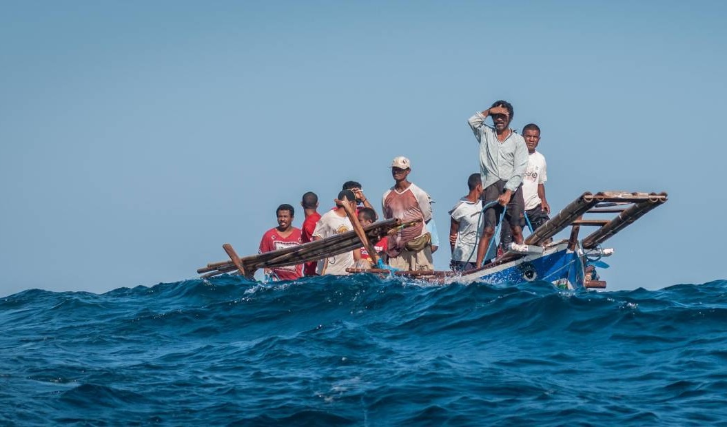 Di tengah Laut Sawu, nelayan memperhatikan gerakan seekor paus yang berenang di dekat peledang, perahu tradisional Lamalera