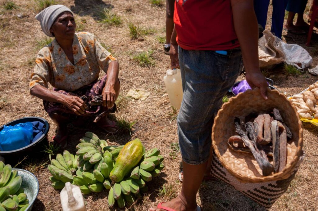 Perempuan Lamalera menjinjing sebakul daging paus yang sudah dikeringkan untuk dibarter dengan sayur dan buah dari wilayah pegunungan Lembata. Foto diambil di pasar barter Wulandoni, Pulau Lembata pada 9 Juni 2022. 